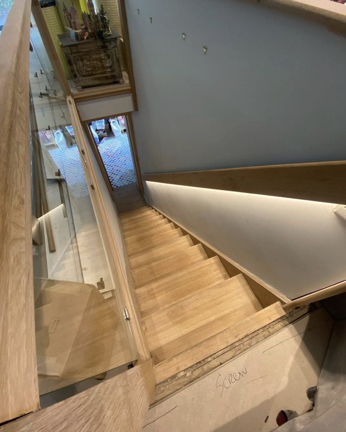 Concealed LED strip lighting under a stair handrail